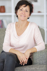 Fototapeta premium portrait of woman sitting near white sofa