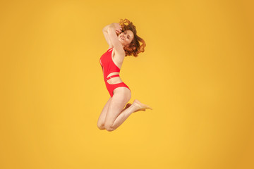 Fototapeta na wymiar beautiful girl in jump on uniform yellow background