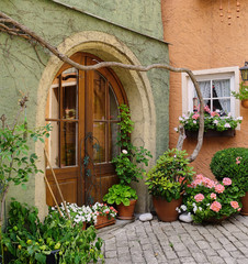 Fototapeta na wymiar Pretty European Garden Entrance with Arched Wooden Door