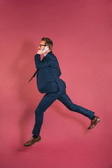 Businessman on the mobile phone jumping