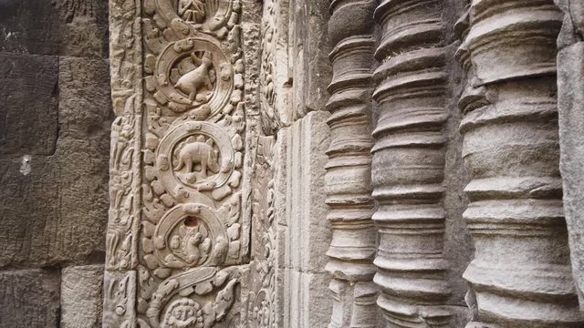ancient bas-reliefs depicting a dinosaur in the ancient temple of TA Prohm. One of the most famous temples of Angkor, TA Prohm is known for its huge trees and roots growing from 