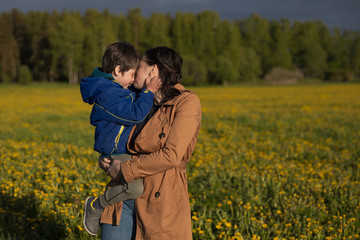 mother walking with her little son on the field.