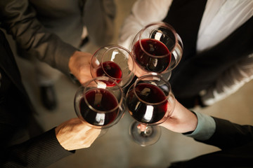 Top view closeup of people in formalwear clinking wine glasses during event, copy space