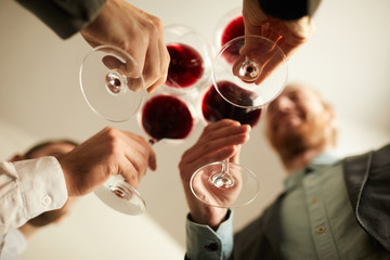 Low angle view at group of people in formalwear clinking wine glasses during event, copy space