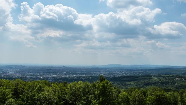 Static timelapse shot of the Vienna skyline with trees in the foreground