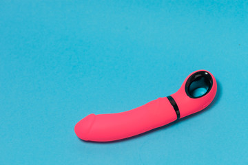 Erotic pleasure toy on a blue background. Sex gadget and masturbation device. A pink rubber and...