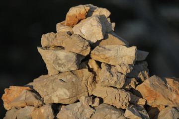 Hand made pile of stones in the mountains during the sunset, close view