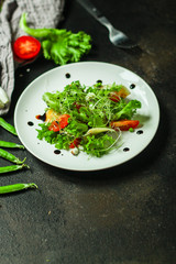salad vegetable - tomato, lettuce, cheese, microgreen and salad dressing. food background. top