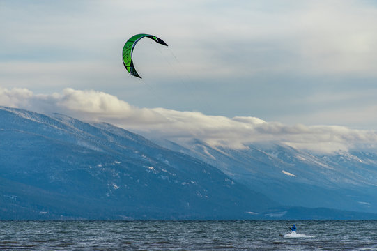 Kite surfer on lake with mountains
