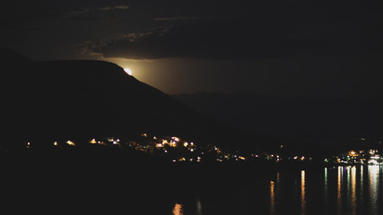 Night view under the moon light onto the city on a shore of Adriatic sea from the rocky hill in...