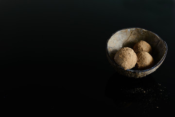 Energy balls of date fruitss and nuts. Raw dessert on a dark background.