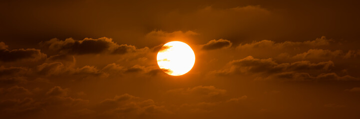Beatiful sunset above the mediterranean sea. Sunrise with red and orange skies and the sun shining. Bright sun with dark background