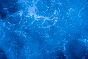 Dark blue deep sea surface, water with sea foam on a stormy day