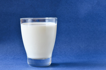 Glass of milk on blue background