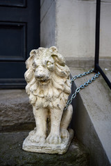lion sculpture made of stone or  gypsum chained in front of a house entrance in the old town of luebeck, germany