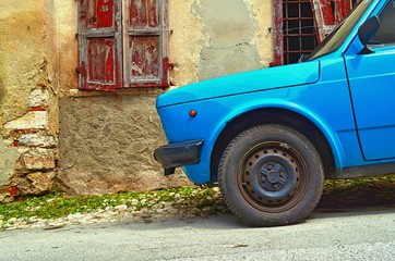 part of the retro car blue standing on the descent, against the wall of the old house