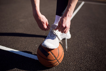 Basketball player tying basketball shoes