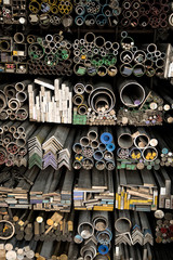 Close up various shape industrial steel products of metal profiles and tubes on warehouse shelf