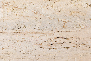 Closeup of beige porous stone textured wall. Neutral beige nature background for design and skins.