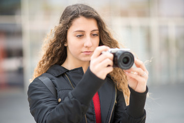 Young woman using a mirrorless camera