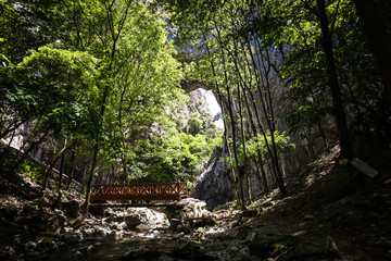 Fototapeta na wymiar Natural stone bridge in Vratna river gorge in Serbia, called Vratnjanske kapije. This arches is a largest natural bridges in Europe.