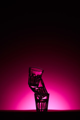 pyramid of glasses on dark background with pink illumination