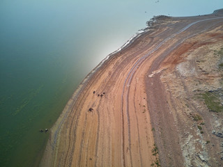 Aerial view of the Valdecañas reservoir, with green water from the algae and natural lines of the...