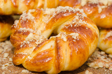 Sweet fresh baked buns with nuts on rustic wooden board 