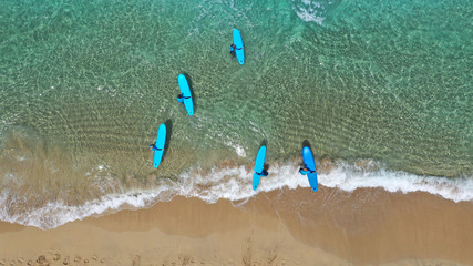Aerial drone top view photo of team of fit surfers enjoying famous sandy wavy turquoise sea sandy...