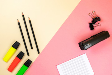 School supplies, notebook and colored markers on pastel pink and beige background. Branding...