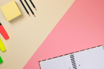 School supplies, notebook and colored markers on pastel pink and beige background. Branding stationery mockup scene, blank objects for placing your design.