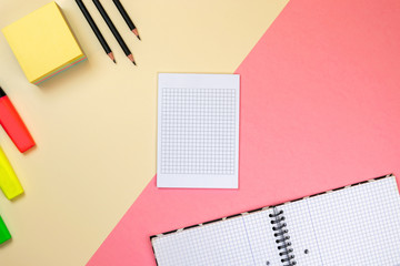 School supplies, notebook and colored markers on pastel pink and beige background. Branding stationery mockup scene, blank objects for placing your design.
