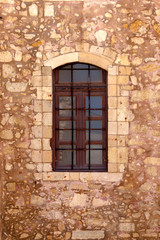 Fototapeta na wymiar The background old beige stony wall with a window