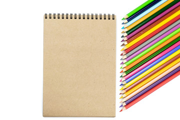 School Concept. Colored pencils, notebooks on brown and beige background. Design concept - Top view of notebook and color pencil collection isolated on white background for mockup