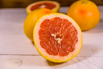Ripe juicy grapefruit on a white wooden table