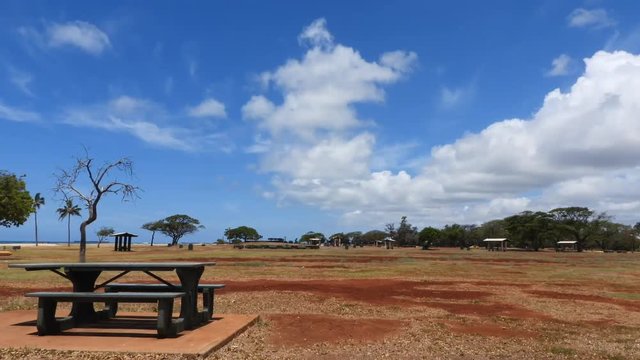 TIME LAPSE with picnic table bench at park with moving clouds.