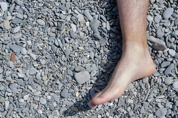 An image of a foot on sea pebbles.