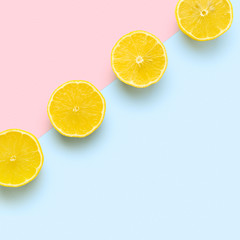 lemon halves in row on pastel pink and blue background. Minimal summer concept. Flat lay, absrtact, trendy pattern.