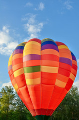 Naklejka premium Colorful hot air balloon heading up in blue sky. Close up.