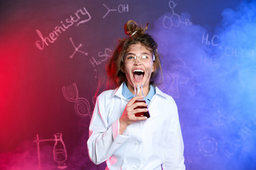 Emotional pupil holding conical flask in smoke against blackboard with chemistry formulas