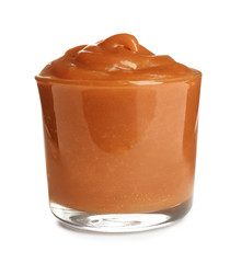 Glass of tasty caramel sauce isolated on white