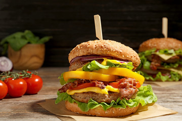 Tasty burger with bacon on table. Space for text