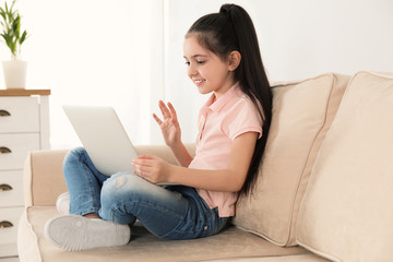Little girl using video chat on laptop at home