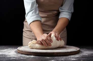 Obraz na płótnie Canvas Female baker preparing bread dough at table, closeup