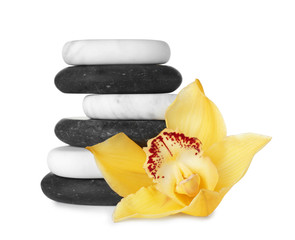 Stack of spa stones and beautiful orchid on white background