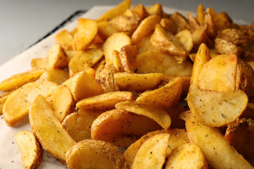Delicious oven baked potatoes on parchment, closeup