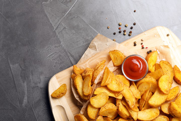 Delicious oven baked potatoes with sauce served on table, top view. Space for text