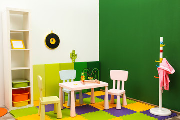 Stylish playroom interior with table and chairs