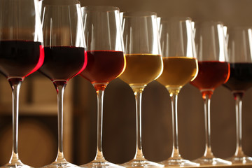 Glasses of different wines against blurred background. Expensive collection