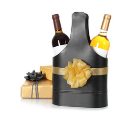 Festive package with bottles of wine and gift boxes on white background